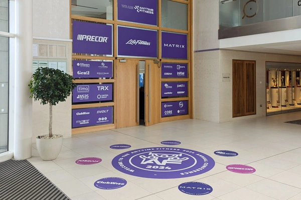 The entrance to the anytime fitness gym conference with floor vinyl prints by the door and logos vinyl prints on the glass